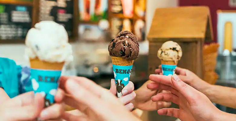 3 handen die ijshoorntjes doorgeven
