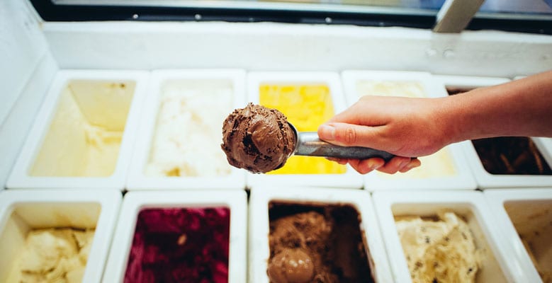 een hand die meerdere smaken ijs schept